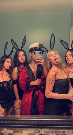 a group of people dressed up in costumes taking a selfie with their cell phone