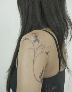 the back of a woman's shoulder with flowers on it