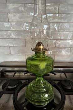 a green glass lamp sitting on top of a stove