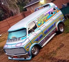 an old school bus painted with graffiti parked in front of a house