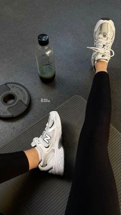 a woman is sitting on a gym mat with her feet propped up in the air