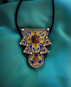 Ancient Berber talisman (herz) in sterling silver, enamelled in blue, green and yellow color. and decorated with a real coral cabochon. Height: 7 cm. Width: 5.5 cm. Leather: 54 cm. ++Material: sterling silver 925, real coral cabochon. ++Weight: 31.8 grams. ++ Origin: Morocco 1970s. Free worldwide shipping by DHL. I am always open to offers for one of my items, so please contact me if you would like to make an offer. Don't hesitate to contact me for any questions. All items advertised for sale ar Traditional Yellow Locket Jewelry, Yellow Pendant Jewelry For Festivals, Amber Pendant Locket Jewelry, Artisan Jewelry For Festivals And Gifts, Artisan Jewelry For Festivals Or Gifts, Vintage Locket Jewelry For Festivals, Vintage Festival Locket Jewelry, Multicolor Round Amulet Pendant Jewelry, Yellow Amulet Necklace As Gift