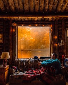 a person sitting on a couch in front of a window