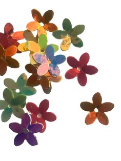 many different colored plastic flowers on a white background