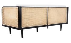 a black and white sideboard with wicker panels