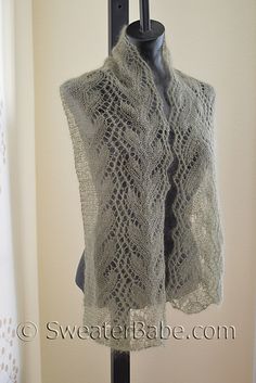 a knitted shawl hanging on a coat rack