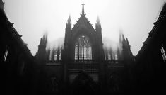 an old gothic church with fog in the air