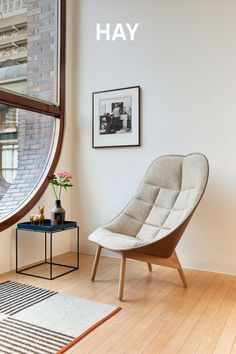 a white chair sitting next to a window in a room