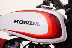 the front end of a red and white motorcycle with honda on it's side