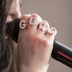 a woman holding a microphone with the word guts spelled on it in front of her face