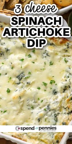 spinach artichoke dip in a white casserole dish with crackers