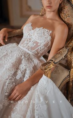 a woman sitting in a chair wearing a wedding dress