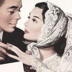 an old photo of a man and woman dressed in wedding attire looking into each other's eyes