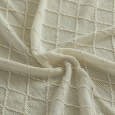 closeup of white fabric textured with small squares and lines on the outside of it