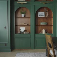 a room with green walls and wooden shelves