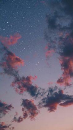 the sky is filled with stars and clouds as the moon shines in the distance