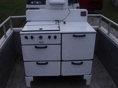 an old white stove sitting in the back of a truck