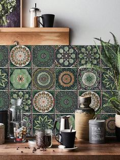 a kitchen counter topped with lots of pots and pans next to a potted plant