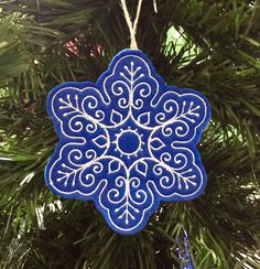 a blue ornament hanging from a christmas tree