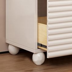 a white cabinet sitting on top of a hard wood floor