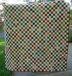 a large quilt is hanging on the sidewalk