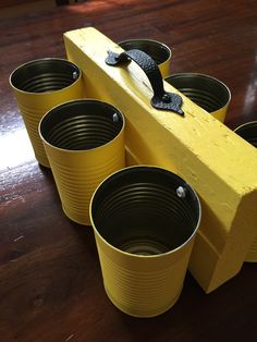 four yellow buckets sitting on top of a wooden table