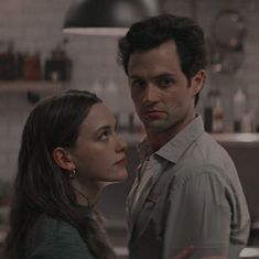 a man standing next to a woman in a kitchen