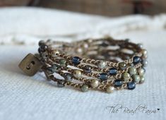 a close up of a bracelet on a white cloth with beads and metal clasps