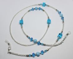 "A lovely glasses chain made using blue tones crystal and glass beads. The glasses chain measures approximately 28\" in length and is finished with rubber ends to securely attach your reading glasses or sunglasses.  Very striking and beautiful chain. Lovely gift idea. Wrapped in tissue paper and presented in an organza pouch." Blue Glass Beaded Chain Jewelry, Blue Beaded Glass Glasses Chains, Blue Glass Necklaces With Adjustable Chain, Blue Beaded Chain Glasses Chains With Round Beads, Adjustable Blue Glass Beaded Necklaces, Blue Beaded Glasses Chains, Handmade Blue Glass Glasses Chains, Light Blue Glass Bead Jewelry, Blue Glasses Chains With Round Beaded Chain