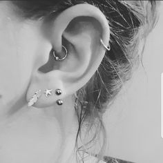 a woman's ear with three piercings on it