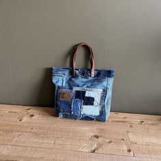 a bag made out of an old pair of jeans with patches on the front and sides