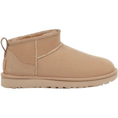 Stay warm and cozy in the cold months with these stylish boots. The UGG Classic Ultra Mini is a casual women's sheepskin ankle boot with a lower shaft height, adding easy on-off and enhanced versatility. These UGG Classic Ultra Mini Sand Sheepskin Women's Boots have the following features: 17mm Twinface sheepskin upper Post-Applied Treatment Treated to repel light amounts of water. The product should be re-treated periodically to maintain protection Asymmetrical topline, Overlock stitch detailin Ugg Ultra Mini, Ugg Classic Ultra Mini, Ugg Mini, Stylish Boots, Flip Flop Shoes, Ugg Classic, Trail Shoes, Suede Heels, Womens Uggs