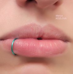 a close up of a person's lips with a ring on their lip,