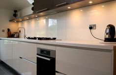 a modern kitchen with white cabinets and black appliances