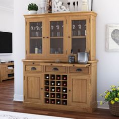 a large wooden cabinet with wine glasses on it's doors and two vases