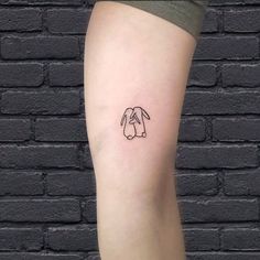 a woman's leg with a small dog tattoo on the left side of her calf