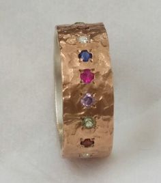 "Multicolored women's ring with birthstones. A sterling silver and 10k red gold ring set with about 20 gems. It can be set with a selection of gems for your desire. Measurements: Width: 0.28 inch / 7 mm Thickness: 0.06 inch / 1.5 mm Gem diameter: 0.08 inch / 2 mm Gemstone selection: Amethyst / Blue topaz (Aquamarine) / Citrine / Coral / Cubic Zirconia / Lapis / black Onyx / Opal / Pearl / Peridot / Red Garnet / Ruby / Sapphire / Turquoise. For other gems, please convo us. Please write your selec Fusion Style Rose Gold Jewelry For Anniversary, Rose Gold Fusion Jewelry For Anniversary, Sterling Silver Rose Gold Multi-stone Jewelry, Rose Gold Multi-stone Sterling Silver Jewelry, Unique Multi-stone Birthstone Ring Gift, Unique Hammered Jewelry For Anniversary, Heirloom Multi-stone Stackable Rings For Gift, Heirloom Style Multi-stone Stackable Rings For Gift, Heirloom Multi-stone Stackable Rings As Gift