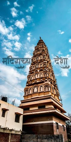 a very tall tower sitting in the middle of a building under a cloudy blue sky