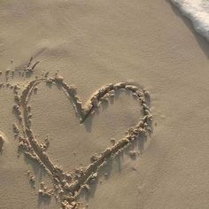 a heart drawn in the sand at the beach