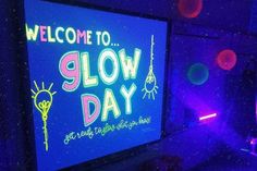 a neon sign that says welcome to glow day on the screen in a dark room