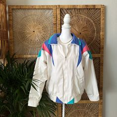 "Shell: 60% Cotton 40% Polyester Lining: 100% Nylon Tagged Small 22\" P2P This 80s inspired jacket is perfect for making a statement. Its unique zip-up design adds a touch of class and modern fashion to any outfit. The Be in the Current Seen Zip-up Jacket is sure to become a staple in your wardrobe. All items are final sale without exception. Items are not eligible for return, refund, or exchange. Please note all of our items are Vintage / second hand. They are likely to have minor flaws due to the nature of being pre - loved items. Some examples of minor flaws include and are not limited to; chips, missing paint, scratches, markings, discolorations, tarnish , and other signs of wear from the previous owner and age." Retro Cotton Windbreaker For Spring, Retro Cotton Track Jacket For Spring, Retro White Windbreaker For Spring, White Retro Windbreaker For Spring, Retro White Spring Windbreaker, Retro White Cotton Outerwear, White Retro Cotton Outerwear, Retro White Cotton Windbreaker, Modern Fashion