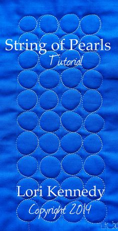 a blue quilt with the words string of pearls in white on it and an image of circles