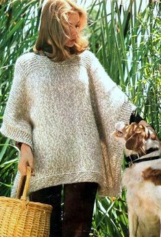 a woman holding a basket next to a dog