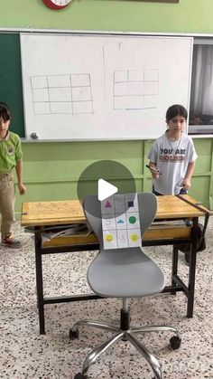 two children standing in front of a desk with a projector on top of it