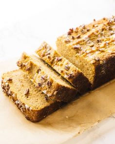 sliced loaf of bread sitting on top of a piece of parchment paper