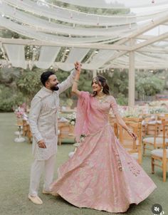 a bride and groom dancing in front of an outdoor tent