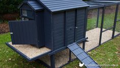 a large chicken coop in the middle of some grass