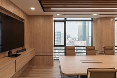 an empty conference room with wooden walls and flooring is shown in front of a cityscape