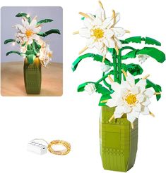 a green vase filled with white flowers next to a couple of wedding bands and ring