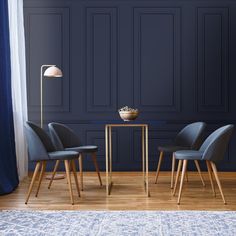 three chairs and a table in front of a blue wall